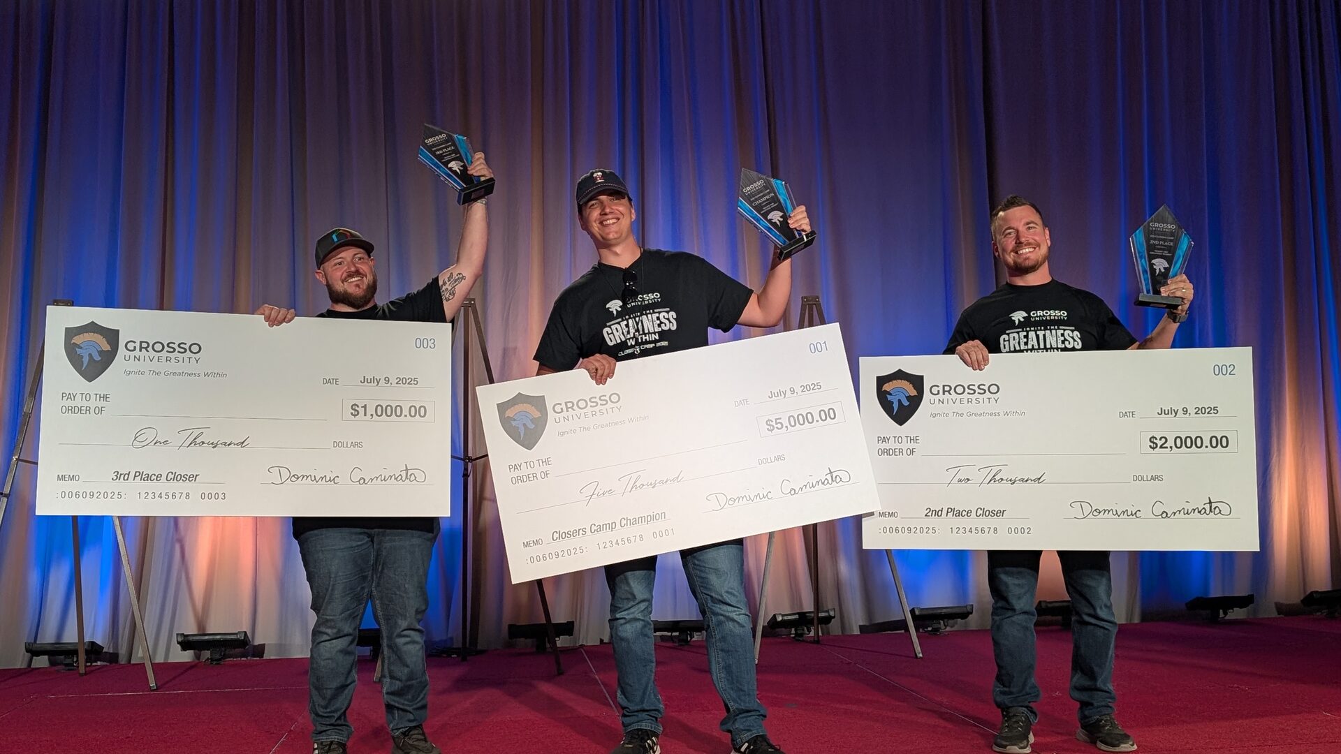 The three Closers Camp 2025 prize winners on stage, each holding an oversized check and a glass trophy.