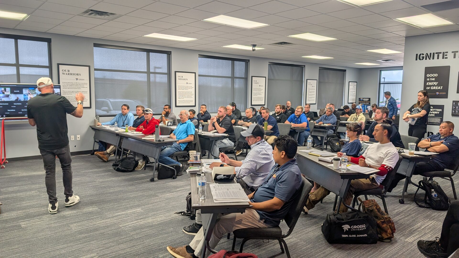 A full Grosso University classroom during Closers Camp 2026, attendees at long tables with workbooks while a presenter works the front of the room.